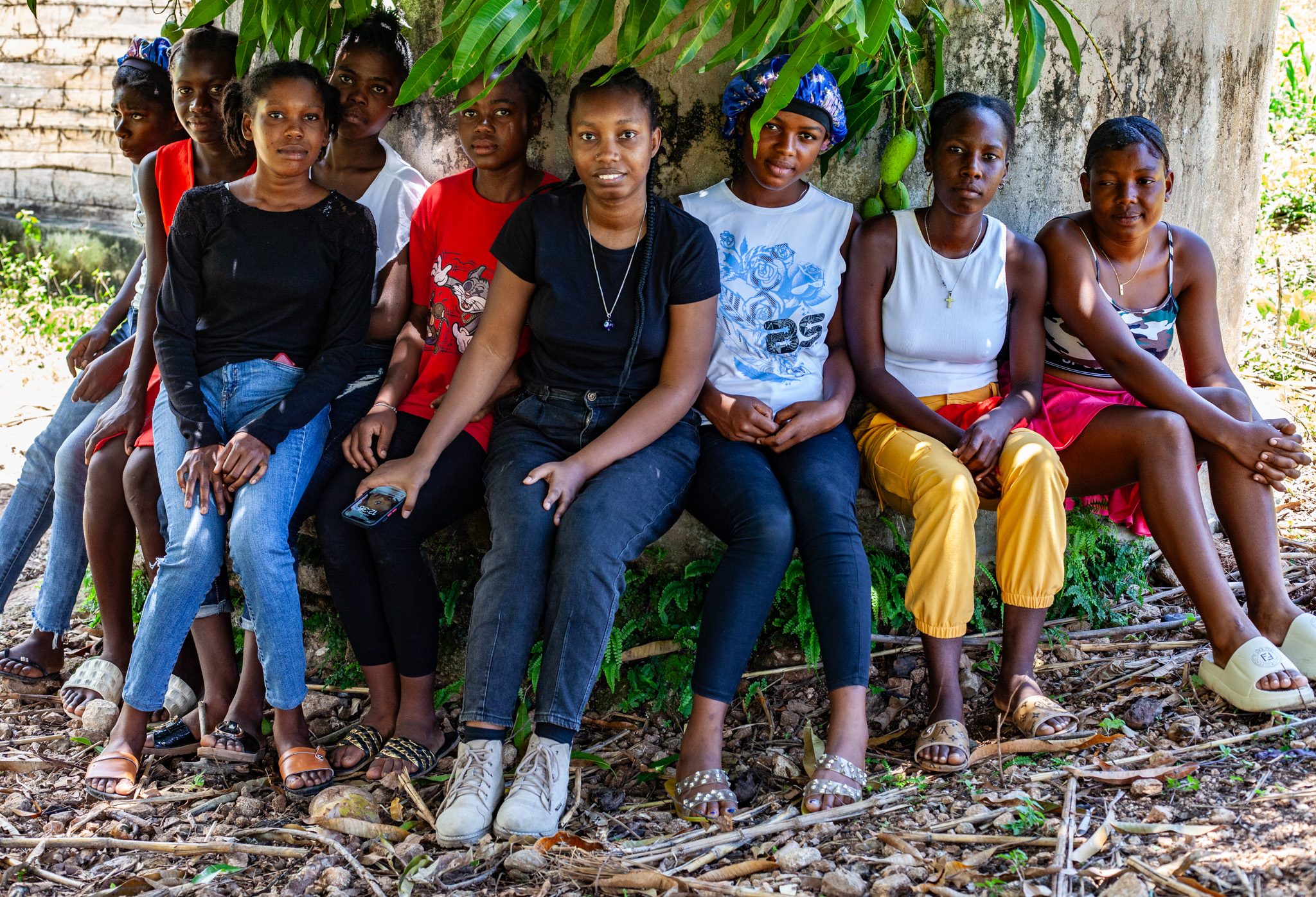 Collectif Kreye members and girls sit together under a tree. 