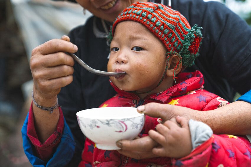 Mother feeds her young child a healthy and nutritious meal