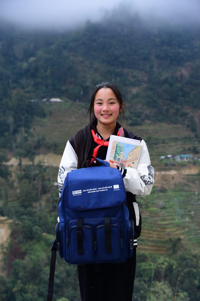 Sào holds her backpack and her school supplies