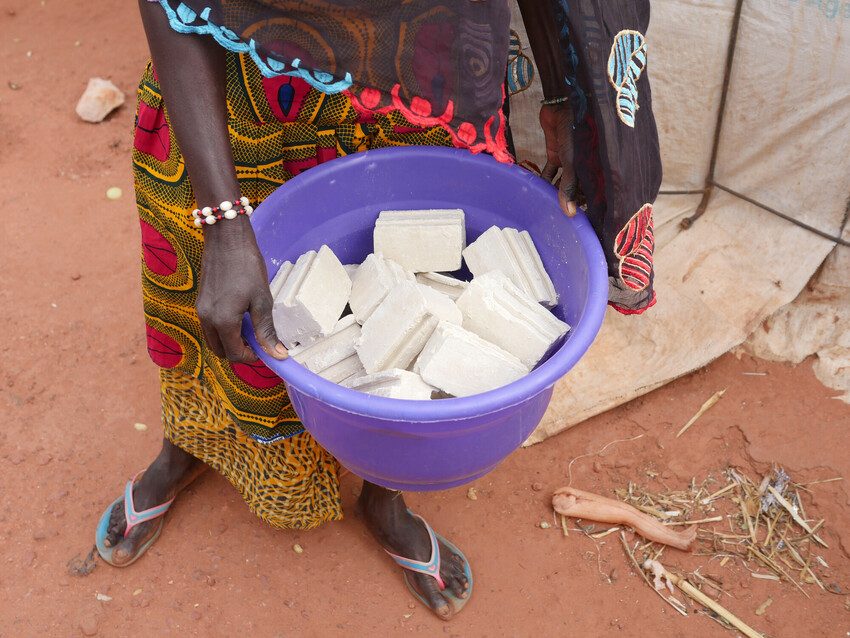 In a displacement camp in Mali, 33-year-old Hamssetou is cutting bars of soap into squares, ready to be sold.  