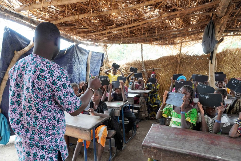 A teacher delivering a lesson to pupils in a Plan International-run accelerated learning centre in Bougouni, Mali.