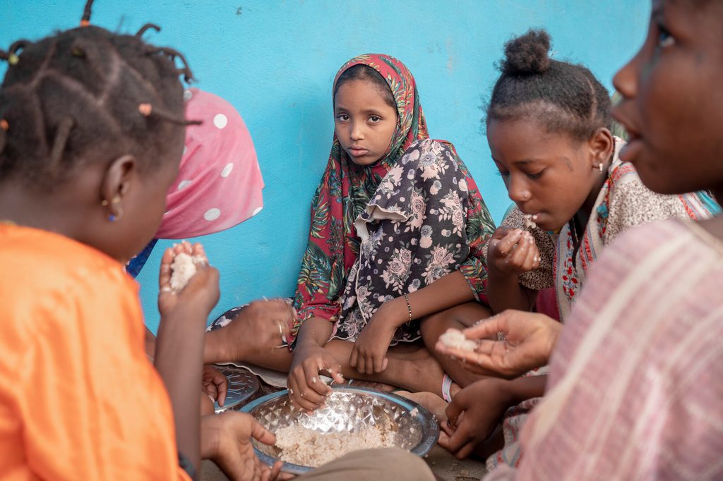 Assiatou shares a meal with her friends. 