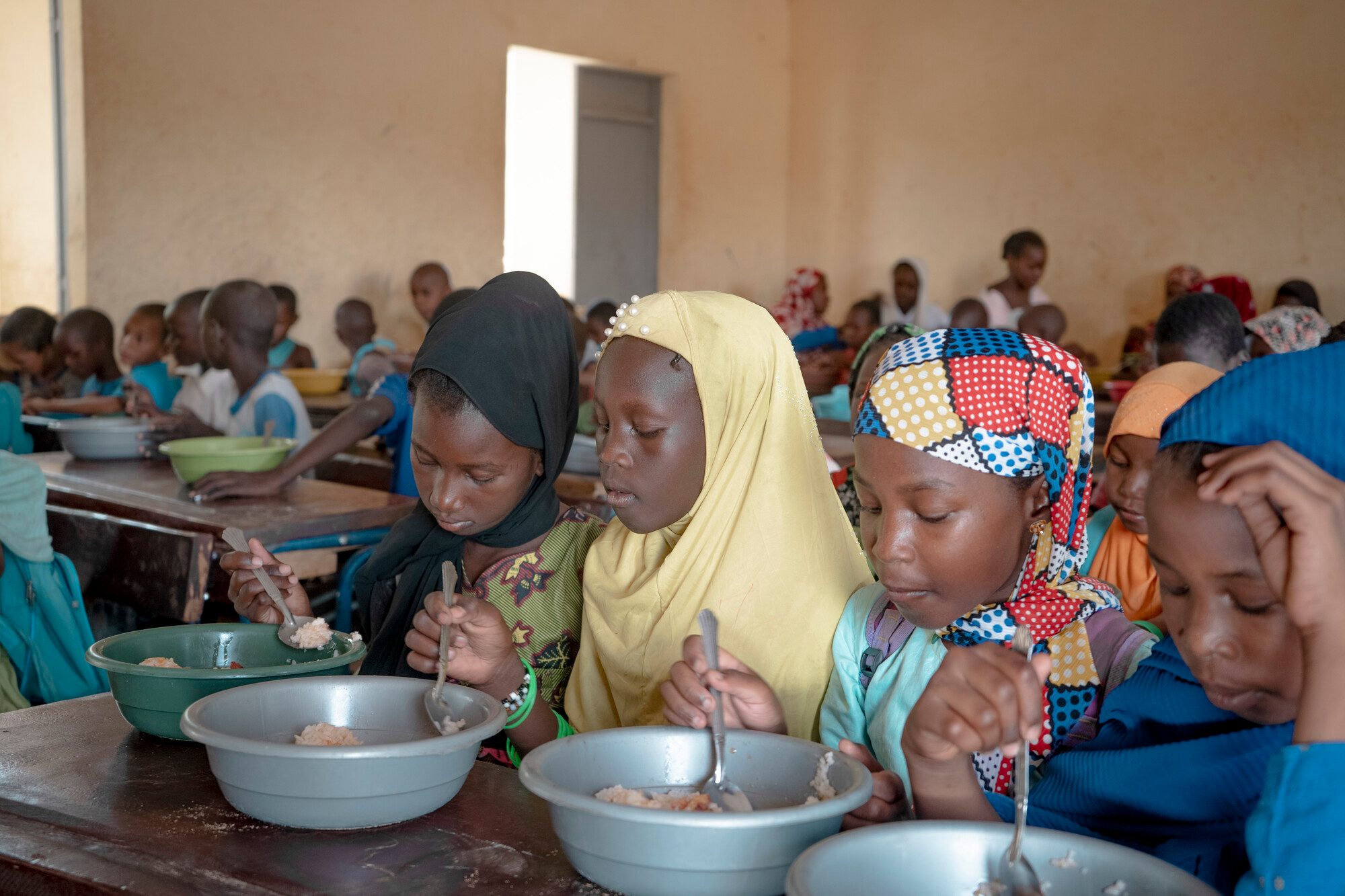 Children eat their lunch in a school classroom.