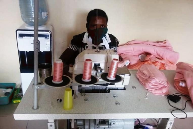 A girl making reusable sanitary pads in Uganda
