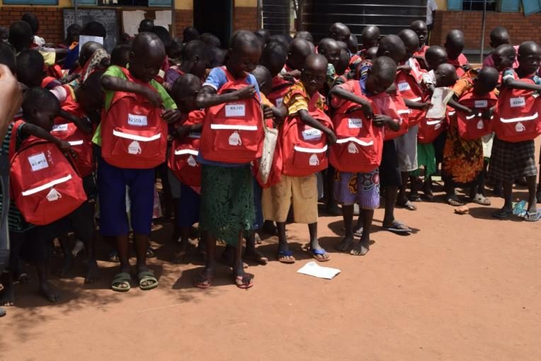 Children receive their school supplies in Uganda.