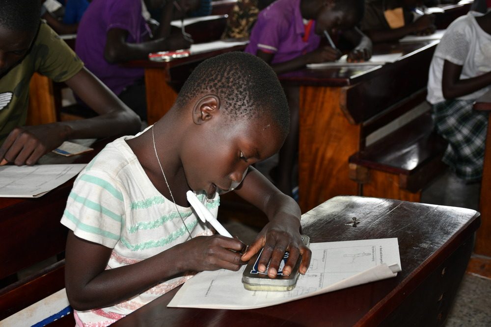 A girl writing at her school desk. 