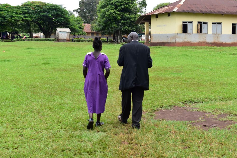 A Baba Club member and a schoolgirl walk together. 