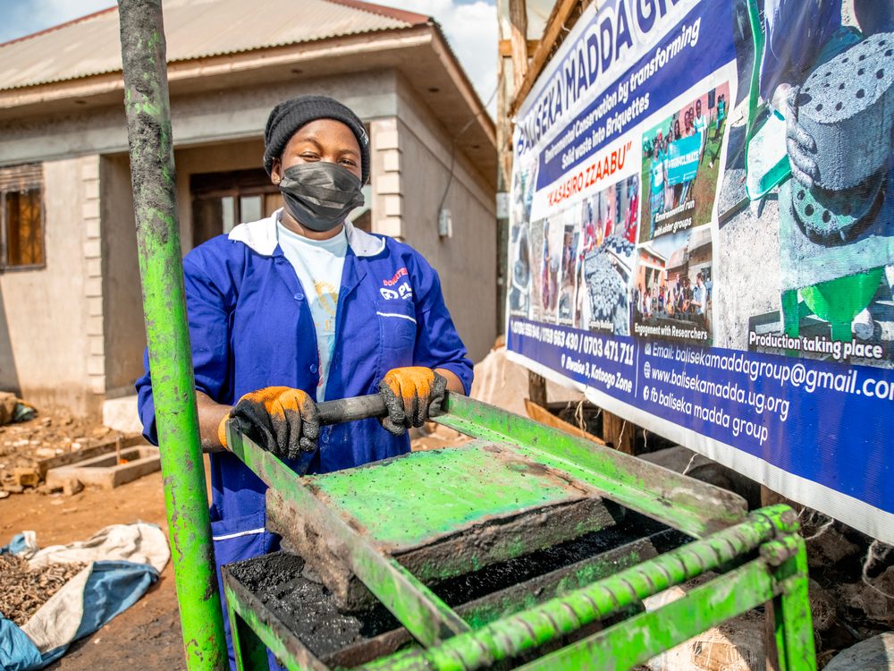 Fatuma using a briquette making machine. 