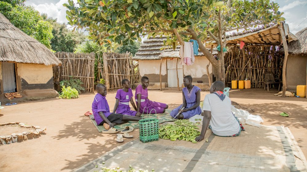 Girls Education club members sit in a group speaking together. 