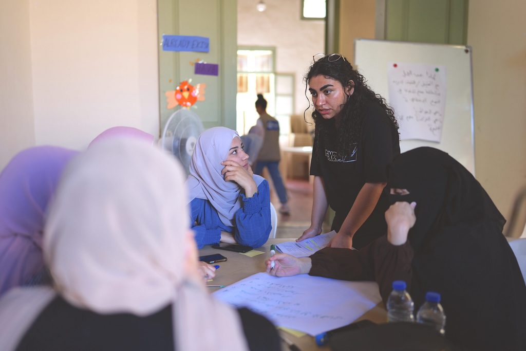 a young woman having a discussion with a group of women