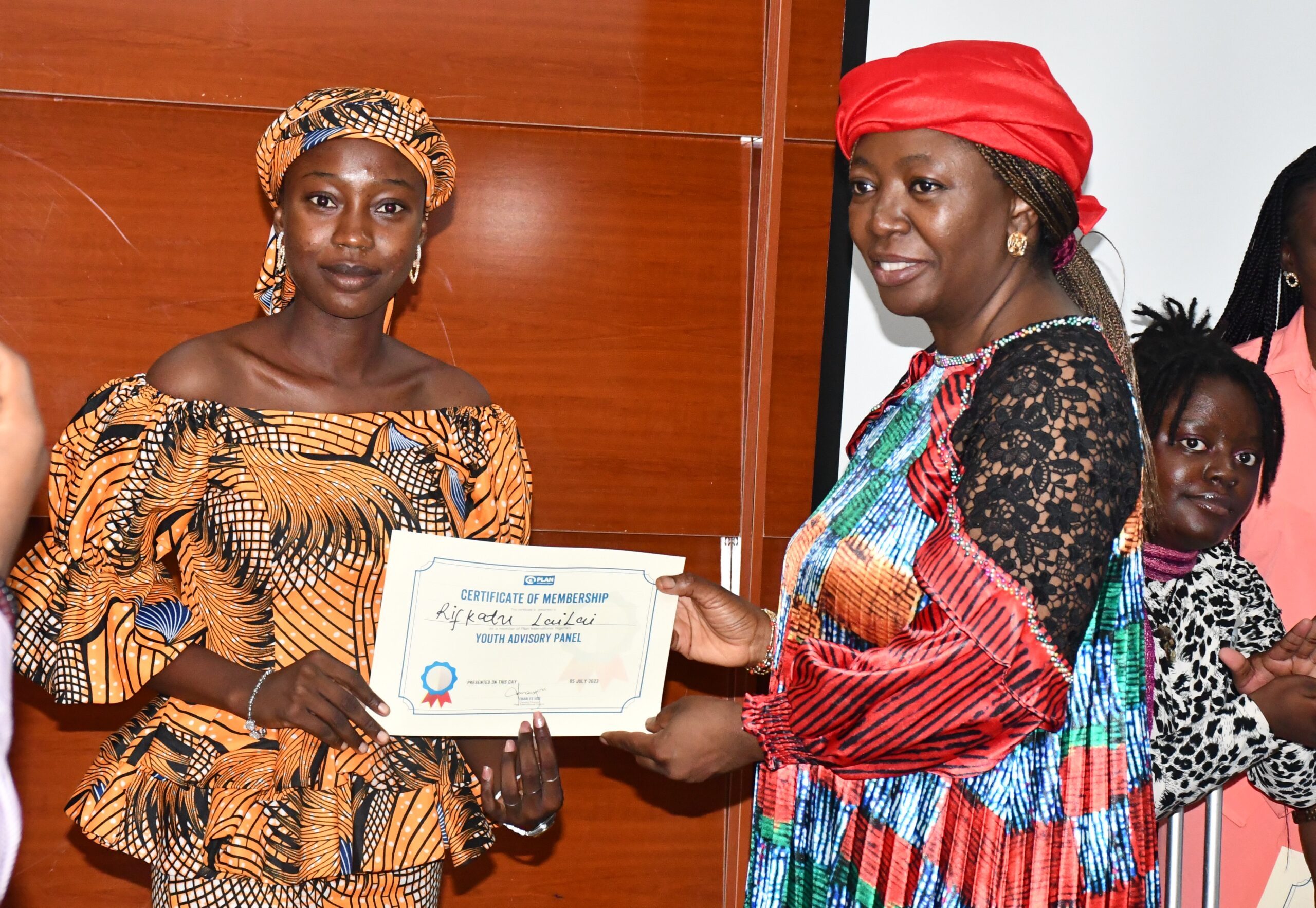 Rifkatu (left) recieving a certificate from Plan International Nigeria's board chair, Dr Nana Chidi-Emmanuel