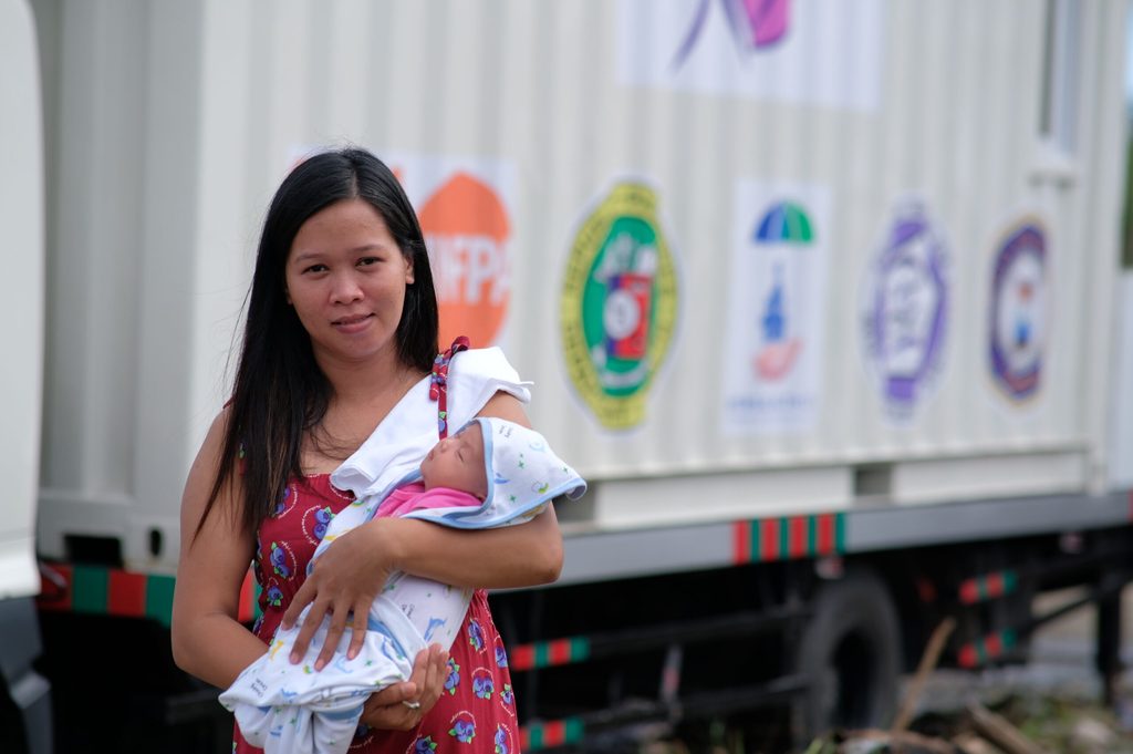 Mariel, the first woman to deliver in the Women’s Health on Wheels, smiles for a portrait with daughter Heart Eunne.