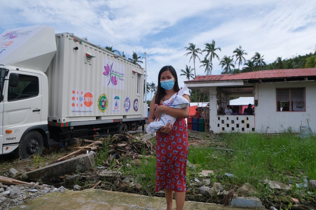 Mariel Bucag and her daughter, Heart Eunne, stand before the Women’s Health on Wheels mobile clinic and St. Bernard Regional Health Unit center