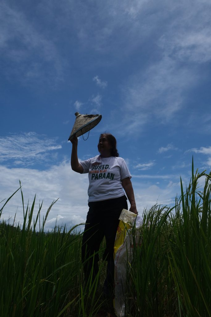 Carmella takes a break after briefly tending to their rice field.