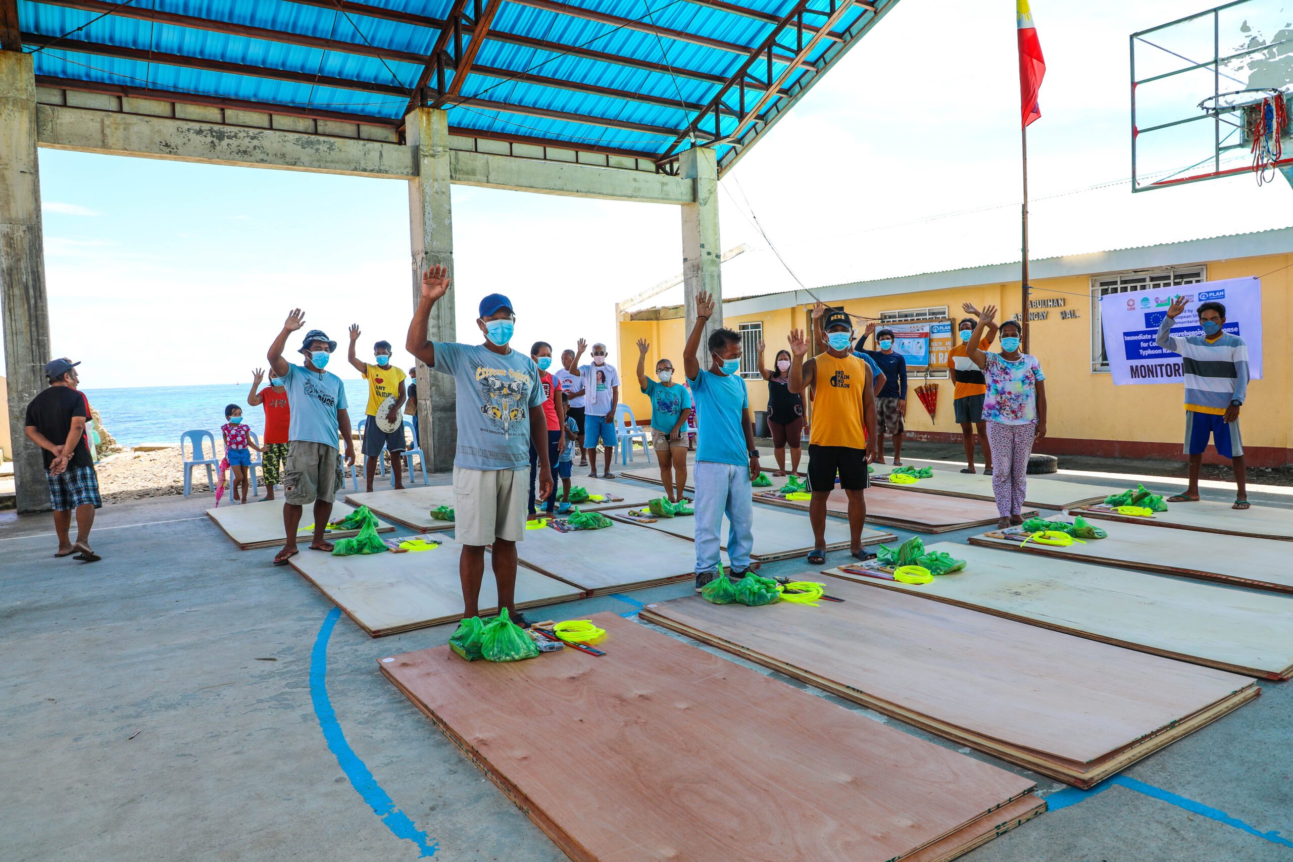 Recipients of the shelter kits, pictured with their new construction materials.