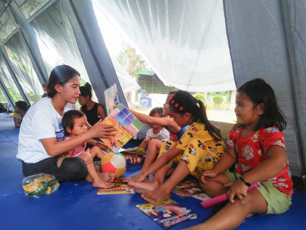 One of Miguela’s team members interacting with the children inside the Child-Friendly Spaces tent 
