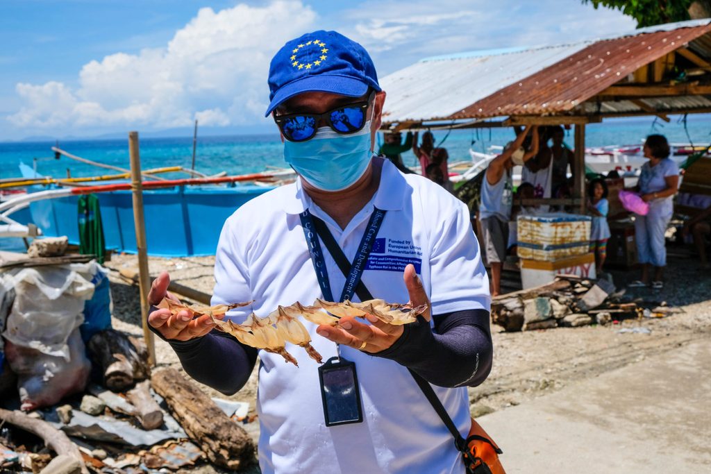 A Plan International staff member holds Limasawa’s most famous product – dried squid 