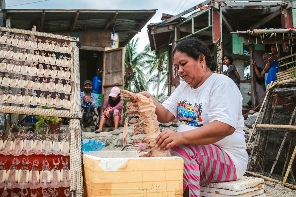 Marina, a resident from Limasawa Island prepares dried squid for packaging