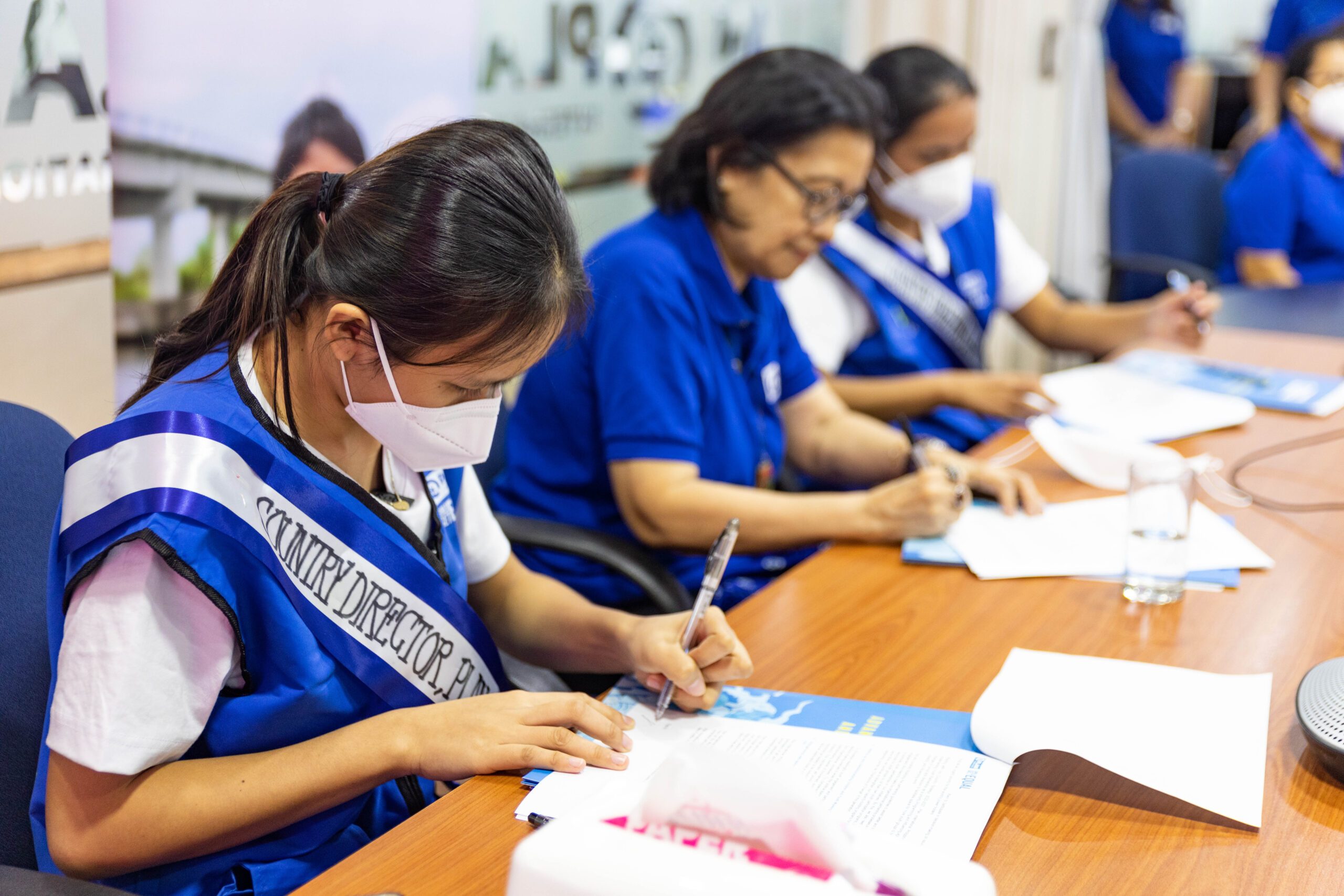 Sponsored children Angelie (left) and Athena (right) sign the Declaration of Support together with Country Director Ana Maria Locsin (middle)