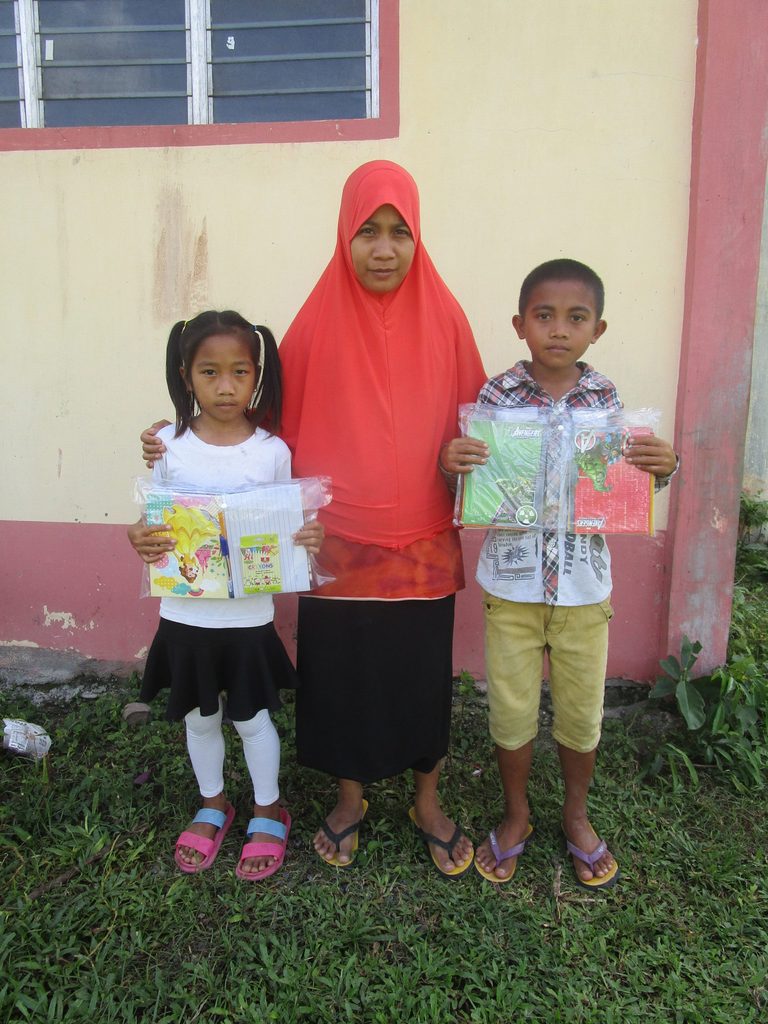 Two sponsored children receive school supplies during the Family Day celebration