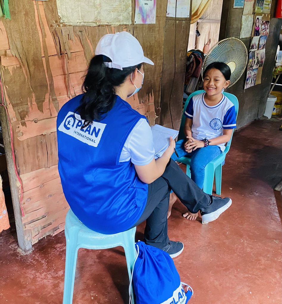Plan International staff interviews girl