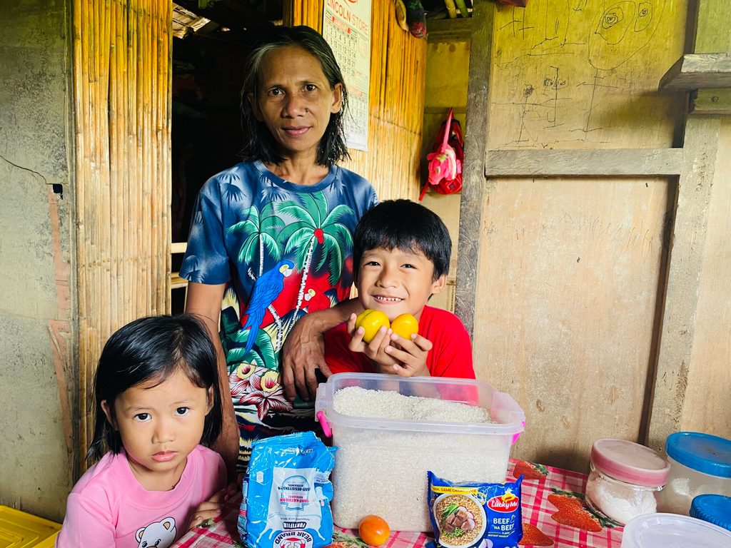 A woman stands between her two grandchildren