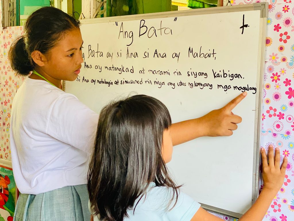 Zyka Mae teaching Luisa how to read