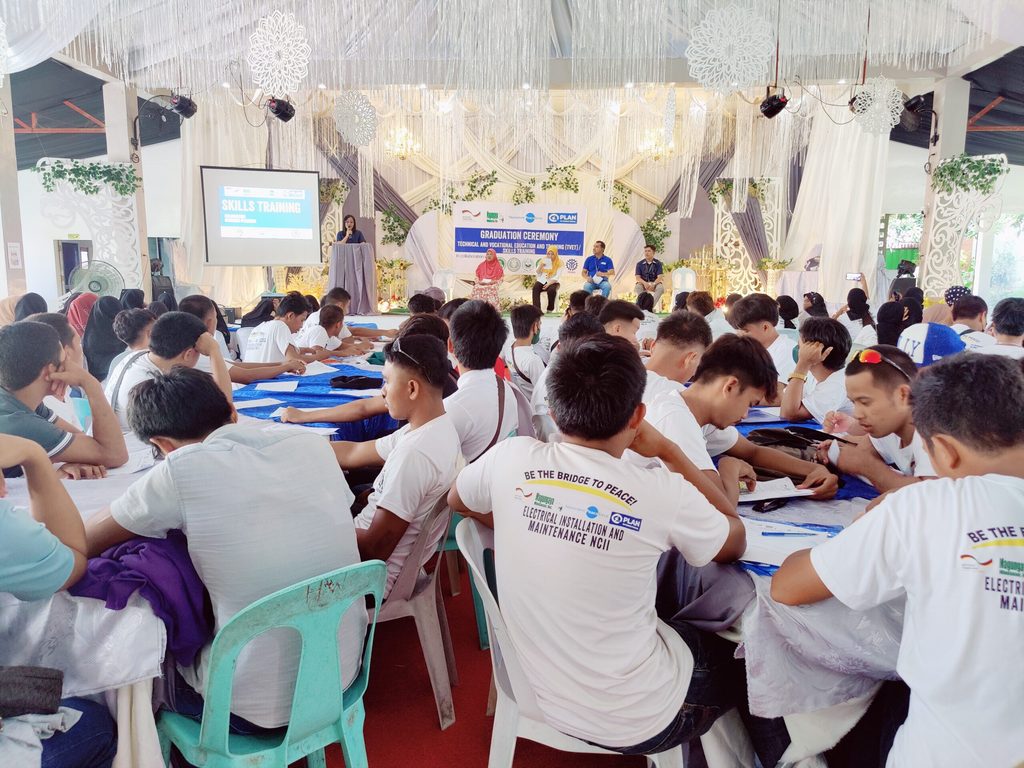 A large group of youth attend their graduation ceremony