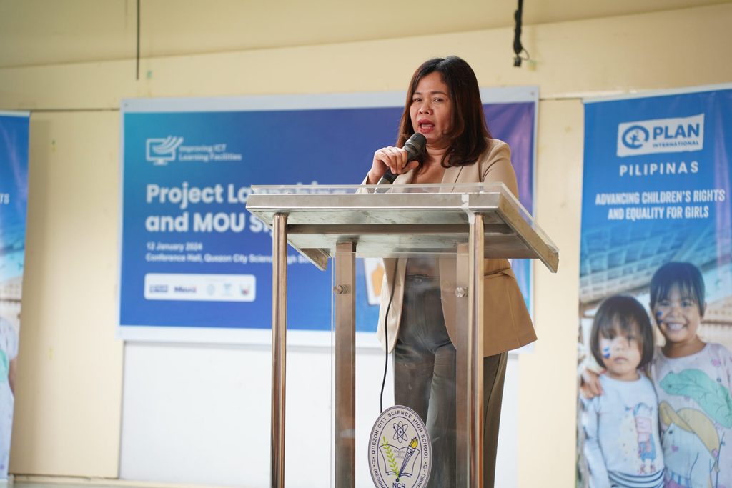 Woman speaks onstage behind a podium