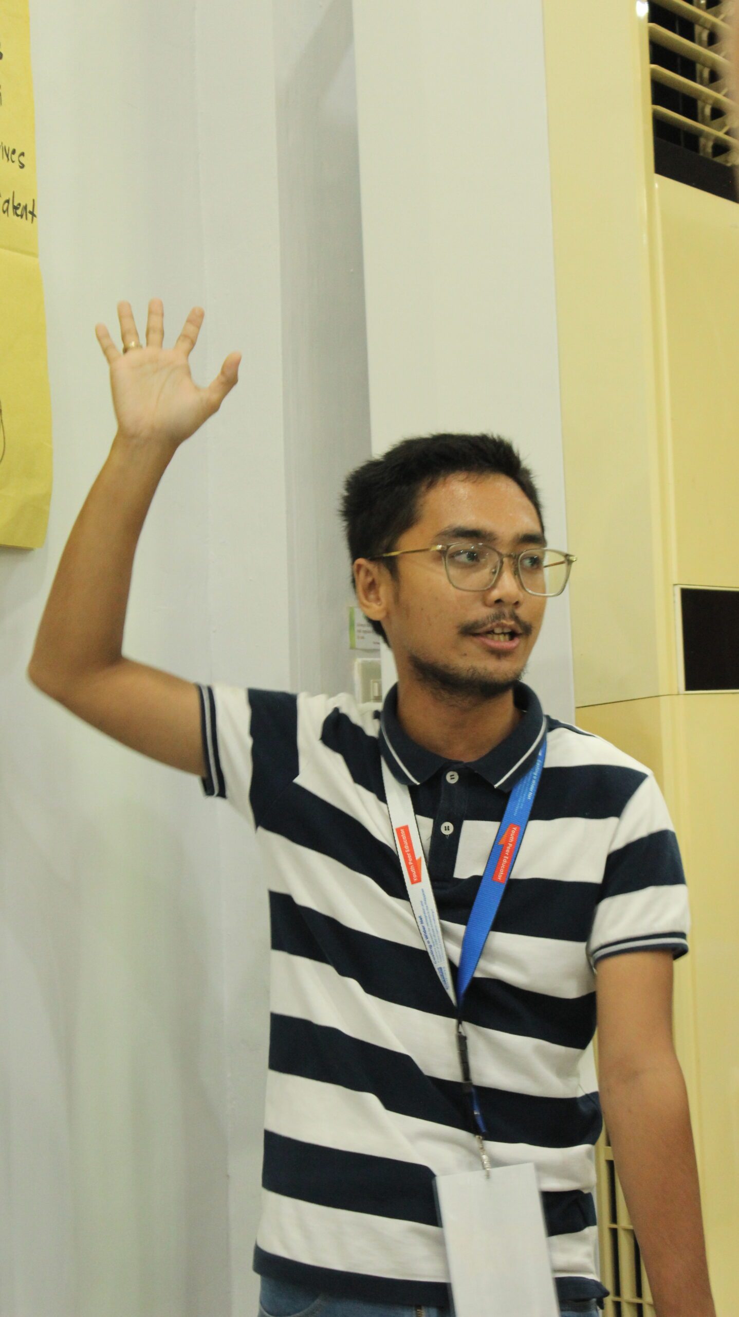 A photo of a boy during his presentation of a report written in Manila paper.
