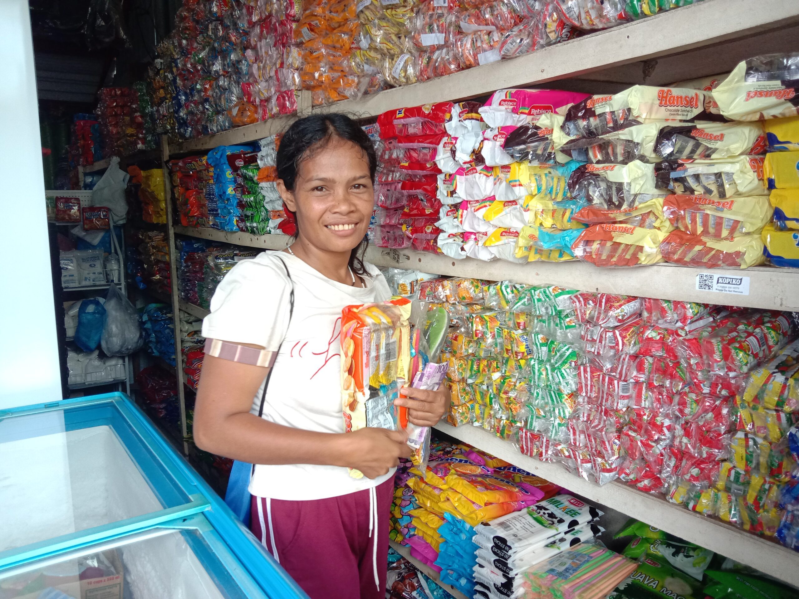 A woman standing inside a store where she bought snacks for her children.