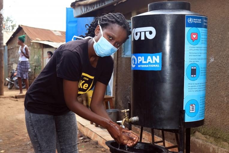 Terry, 24, washes her hands at one of the hand-washing stations in Kibera