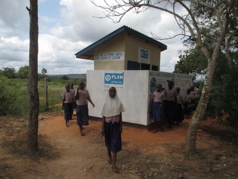 A group of young girls exiting their newly constructed gender friendly latrines at school