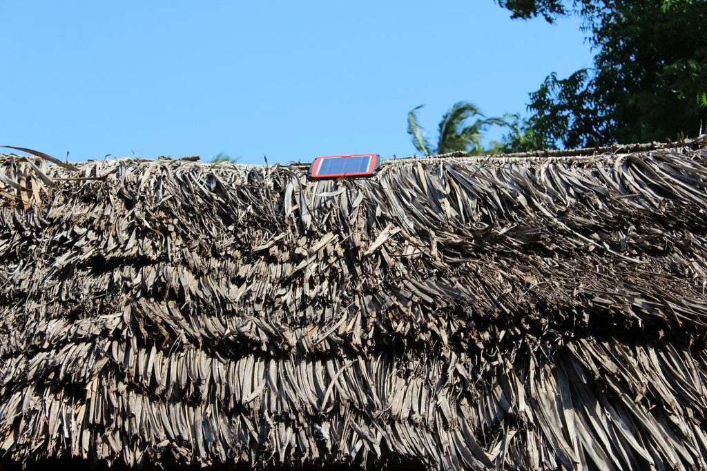 A solar panel installed on top of a thatched house in Kilifi County