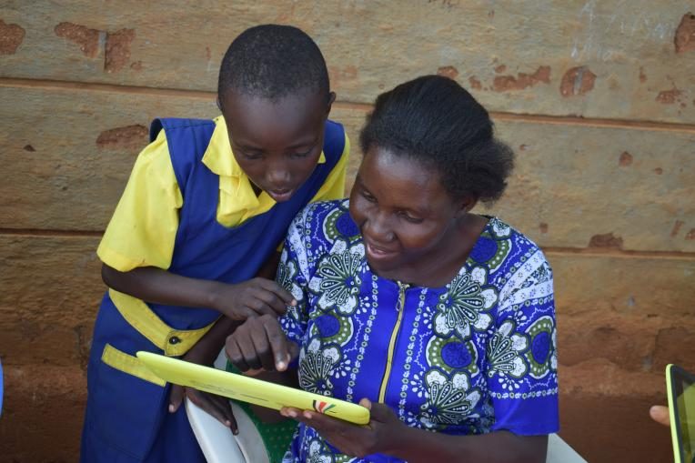 A teacher and a pupil going through content on a tablet