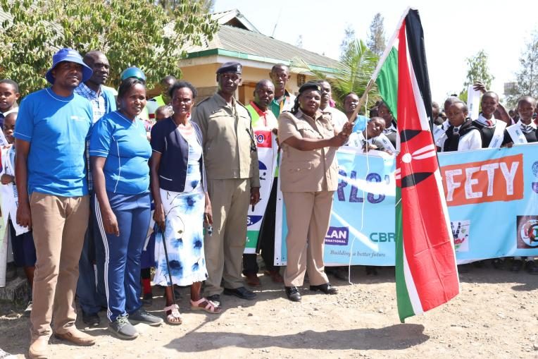 The Assistant County Commissioner waving her flag at the graduation ceremony