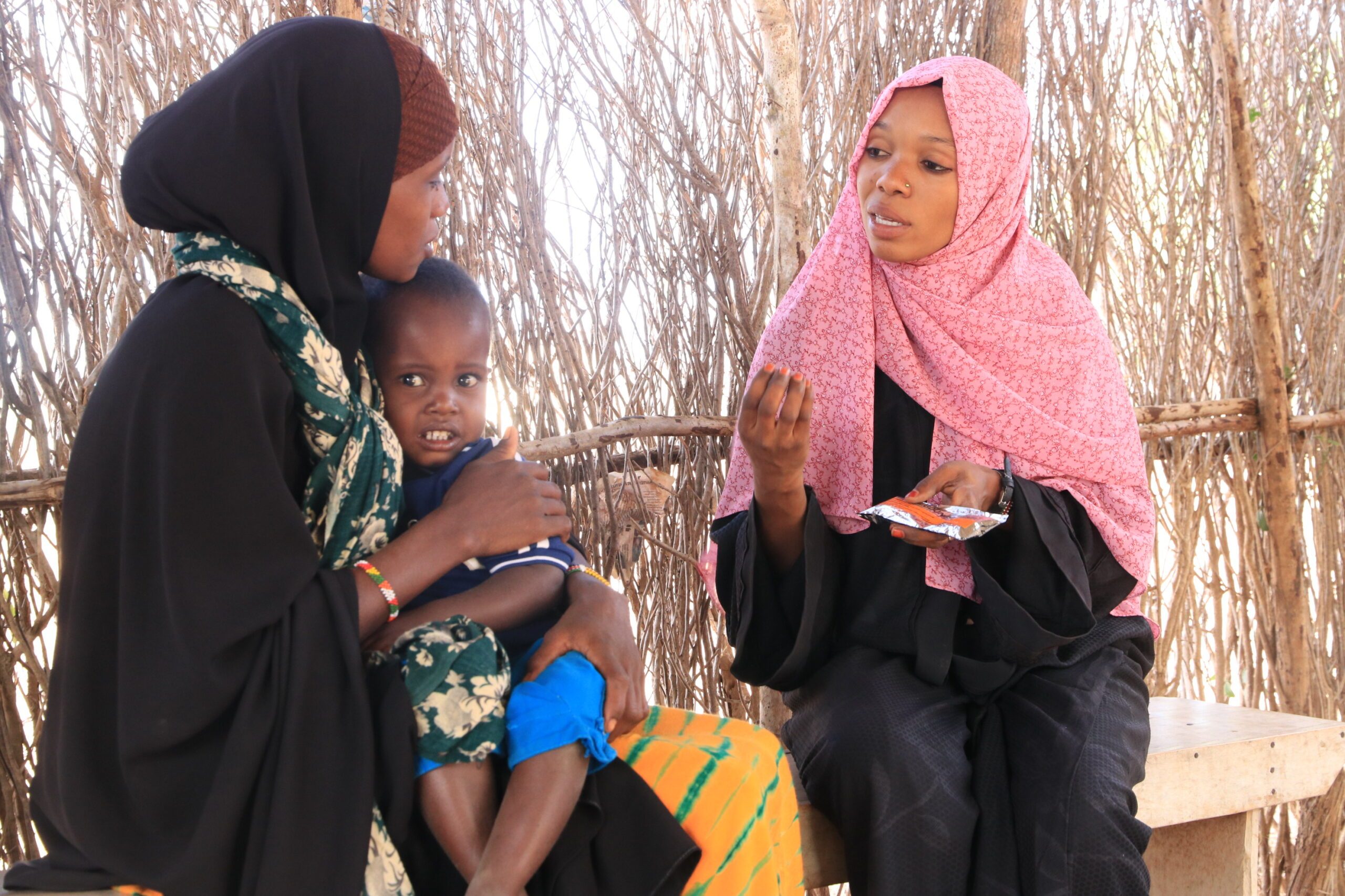 Mwanadie explains to a mother how to administer ready-to-use therapeutic foods