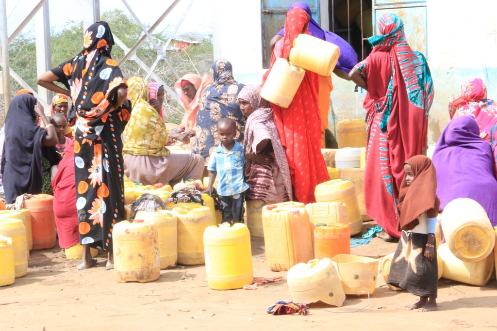 Girls and women waiting to collect water in Kenya