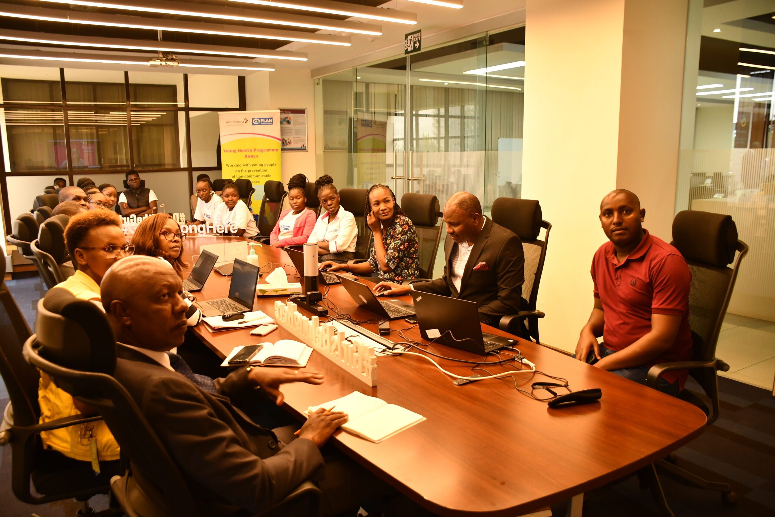 Young advocates and AstraZeneca staff are sitting around a conference table. 