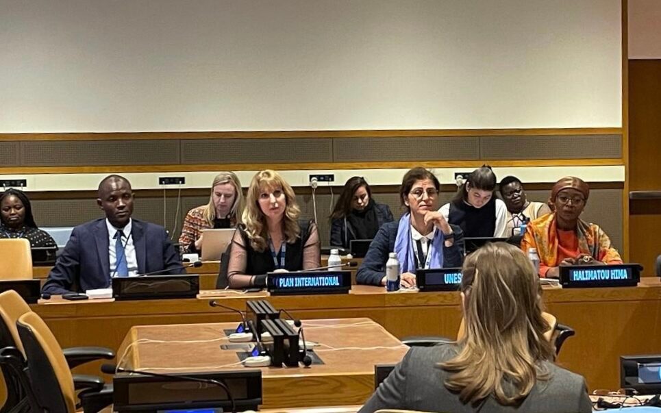 Plan International Staff at a security council meeting sitting at their desks with their organisation's name in front of them.