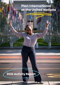 A young girl in front of the United Nations in Geneva, smiling and using both hands to give peace signs.