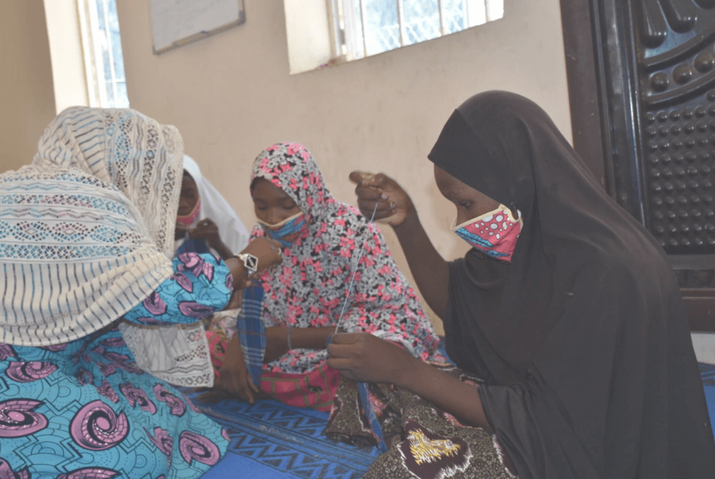 Women working while wearing masks.