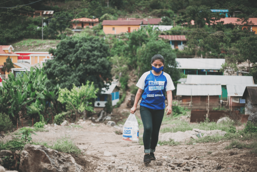 Girl walking outside, wearing a mask.