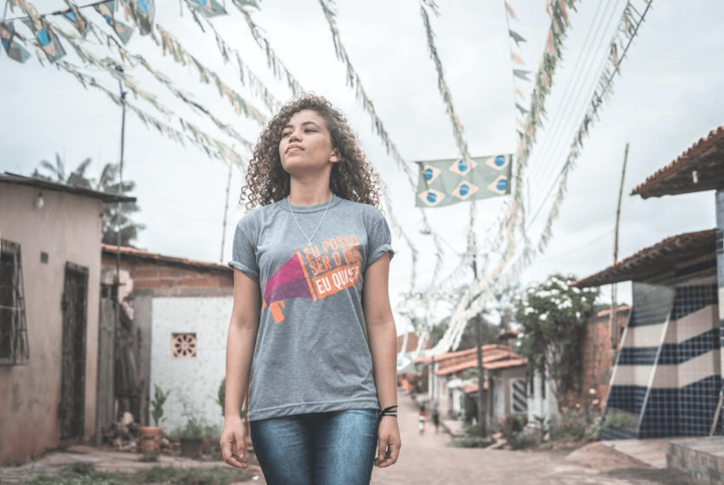 Girl standing proudly  in front of a street in her village.