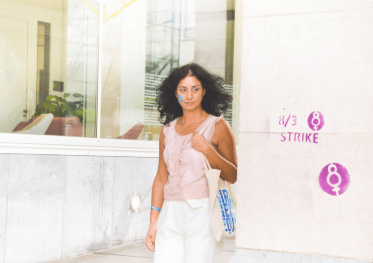 Woman walking in front of strike symbol