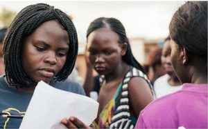 Girl reading a piece of paper.