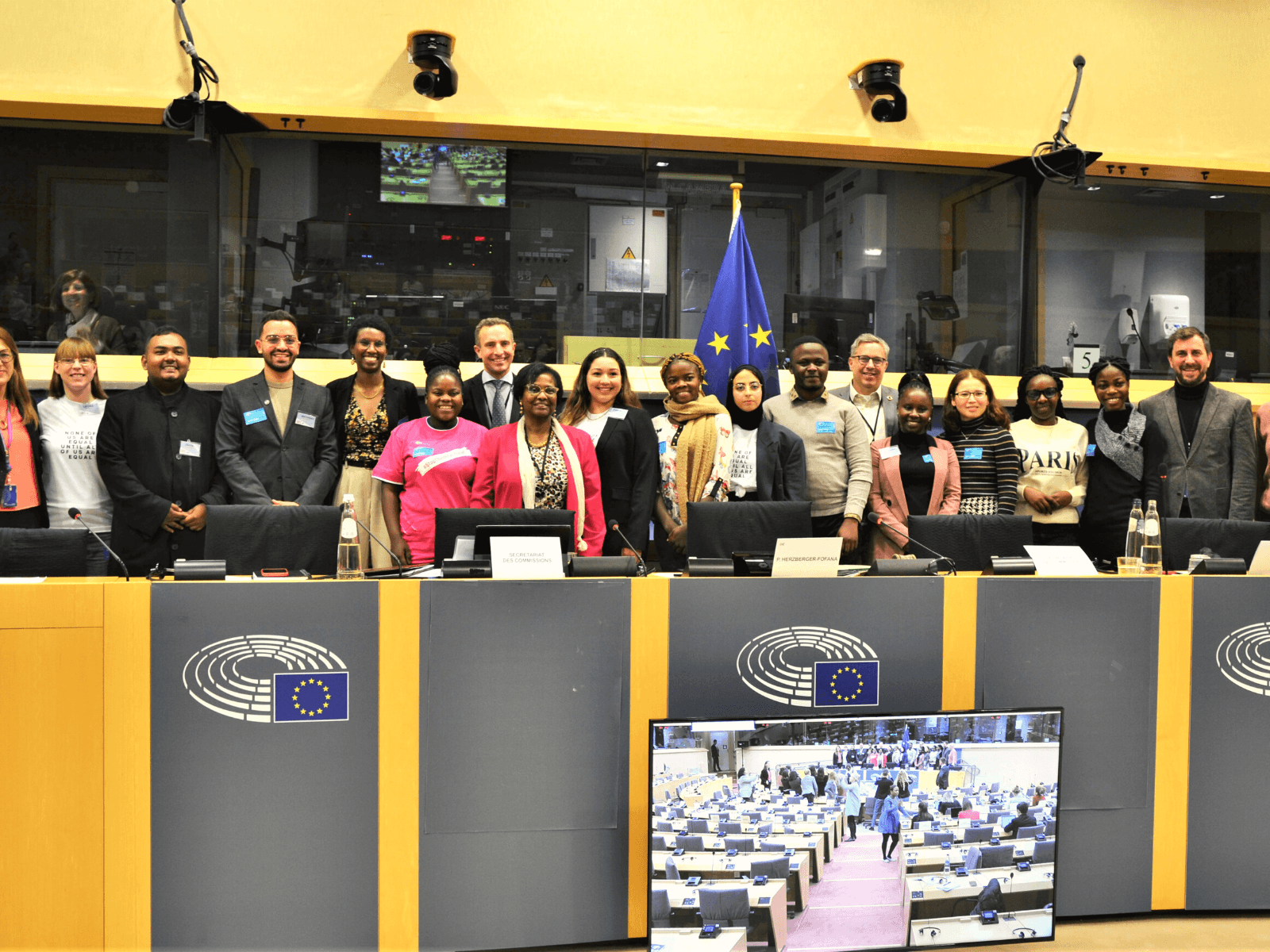Young activists from the 2022 European Week of Action for Girls group posing with Members of the European Parliament in the hearing of the European Parliament Development Committee hearing.