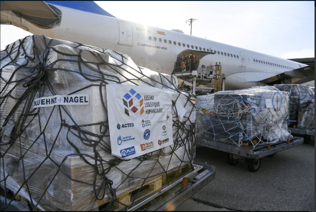 Photograph of humanitarian supplies as cargo outside an airplane.