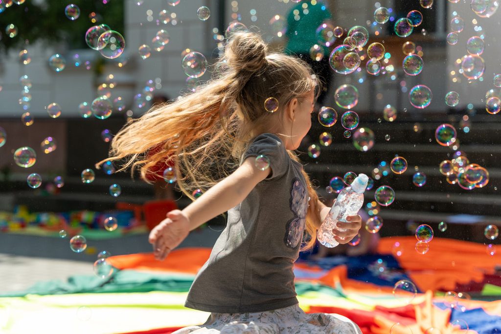 Girl playing outside under the sun, Moldova.