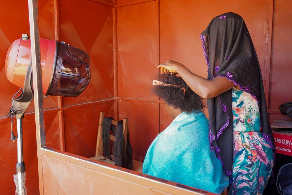 Soudata working on a client's hair in her salon.